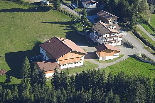 Huterhof v léte: zde je videt nove postavená hospodárská budova a obytný dum s hrištem za ní.