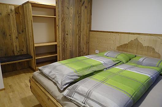 Ložnice s laserem gravírovanou fotkou Schlernu a šatnou v rekreacním apartmánu "Schmetterling"