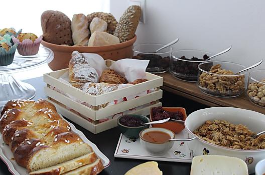 Snídaně s domácími copánky, muffiny, pomazánkami a granolou.