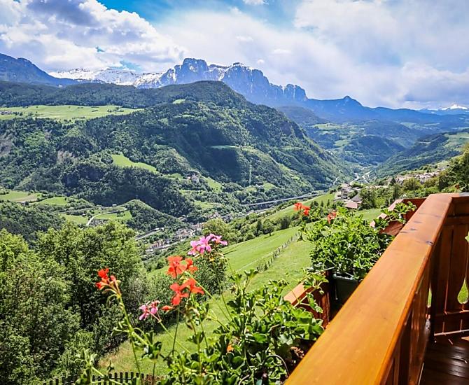 Wundervolle Aussicht auf die Dolomiten, das Grödnertal, den Schlern, die Seiser Alm. Balkon mit Esstisch, Frühstücksgenuss im Sonnenschein. 