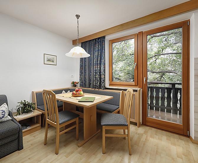 Der geräumige Wohnraum verfügt über eine gemütliche Sitzecke, eine Doppelbettcouch und einen eigenen Balkon zum Nussbaum.