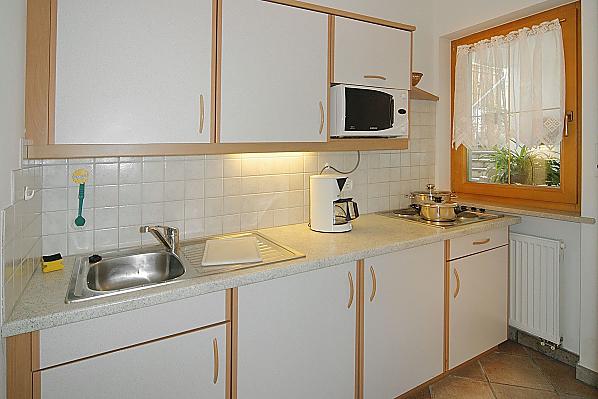 Separate Küche komplett ausgestattet mit Spülmaschine, Kaffeemaschine, Wasserkocher und Mikrowelle.