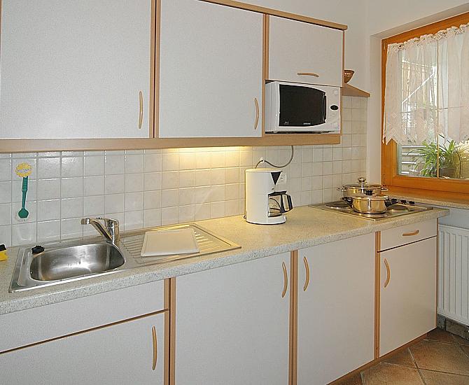 Separate Küche komplett ausgestattet mit Spülmaschine, Kaffeemaschine, Wasserkocher und Mikrowelle.