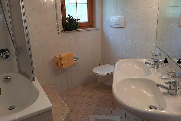 Bad mit Sitzbadewanne/Dusche, WC, Doppelwaschbecken und Handtuchtrockner