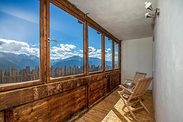 Verglaster Balkon mit Aussicht auf die umliegenden Berge