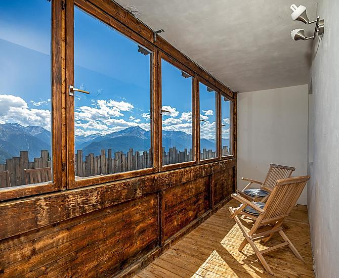 Verglaster Balkon mit Aussicht auf die umliegenden Berge