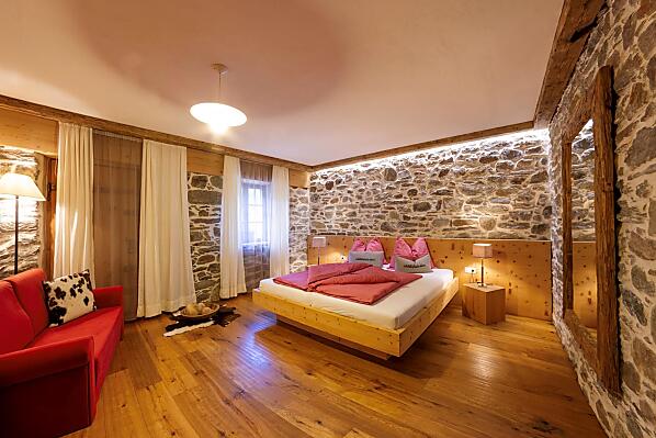 Das Schlafzimmer in der Schildhofsuite beinhaltet ein Doppelbett und ein Sofa