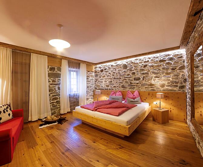 Das Schlafzimmer in der Schildhofsuite beinhaltet ein Doppelbett und ein Sofa