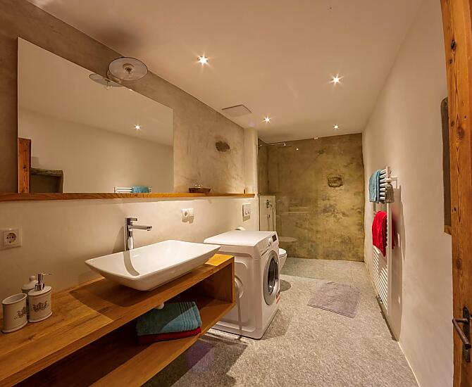 Das Badezimmer in der Schildhofsuite besteht aus einer Dusche, einem WC sowie einer Waschmaschine.