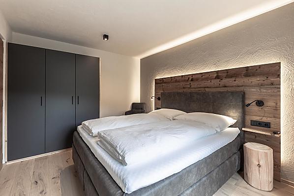 Schlafzimmer mit Holzboden und Akzenten aus Altholz.