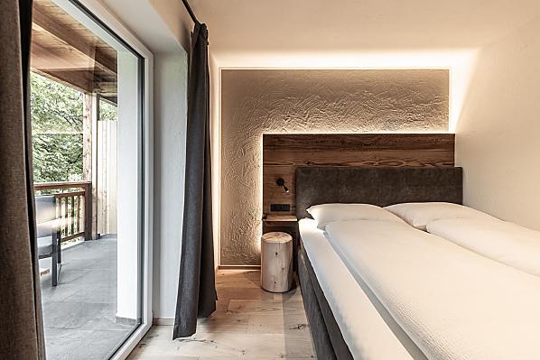 Schlafzimmer mit Holzboden und Akzenten aus Altholz.