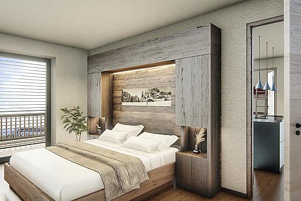 Schlafzimmer mit Holzboden und Einrichtung aus Altholz.