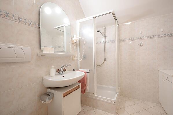 Badezimmer mit Dusche, WC und Haartrockner.