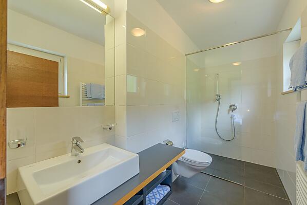 Helles, großes Badezimmer mit begehbarer Dusche/WC, Föhn, Handtücher, Badetücher, vom Schlafzimmer aus zugänglich.