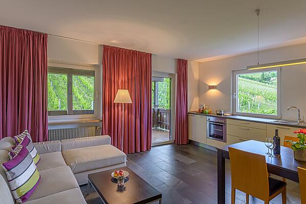 Wohnküche mit überdachter Terrasse, Weinbergblick, Ausblick nach Tramin und auf den Infinity-Pool mit Liegewiese
