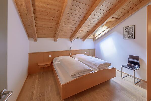 Ruhiges Schlafzimmer mit Doppelbett und dreiteiligem Schrank